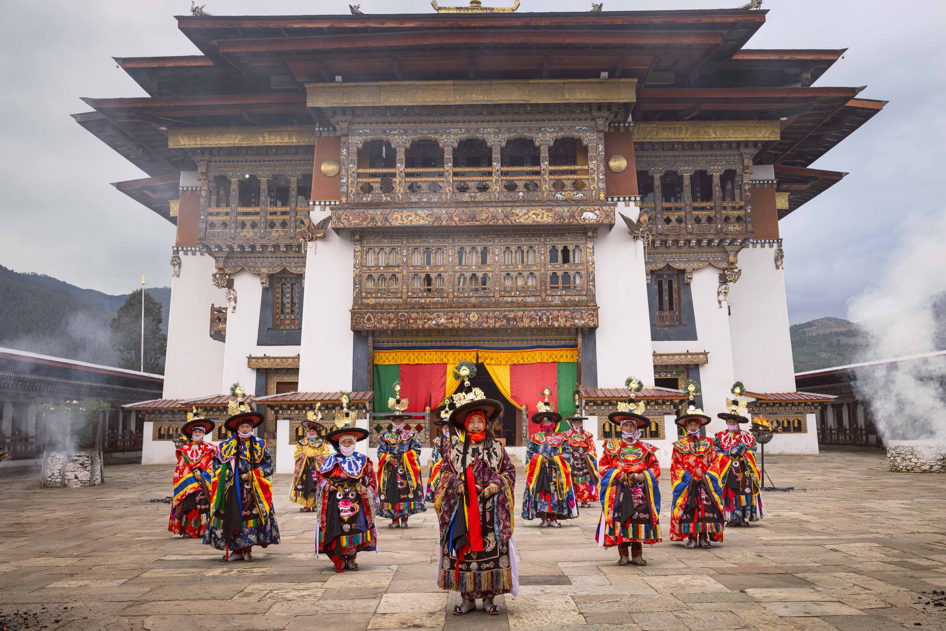A monk crossing a dzong courtyard in mist